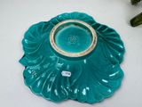 a teal plate with a gold rim on a white table