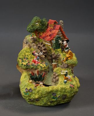 two figurines of a small house on a rock