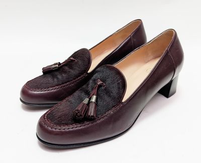 Les chaussures de cette femme sont en cuir et ornées de pompons.