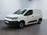 La camionnette blanche est garée dans une grande pièce blanche.