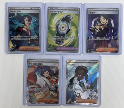 six card set of pokemon trading cards in plastic cases on a white surface