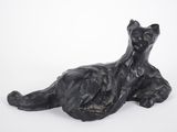 sculpture représentant un chat noir couché sur une surface blanche