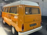 a yellow van parked in a garage with a white roof