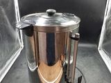 a silver kettle sitting inside of a glass case