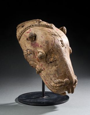 une tête de cheval antique posée sur un socle, sur fond noir