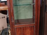 une petite armoire avec une porte vitrée au milieu