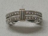 a silver ring with three rows of diamonds on it