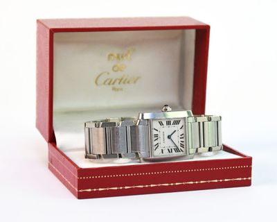 une image représentant une montre Cartier dans un coffret rouge sur fond blanc