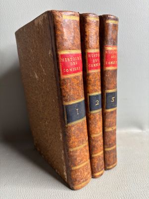 trois vieux livres posés l'un sur l'autre sur une table