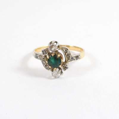 un gros plan d'une bague en or ornée d'une pierre verte au centre