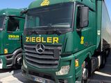 deux camions verts garés l'un à côté de l'autre sur un parking