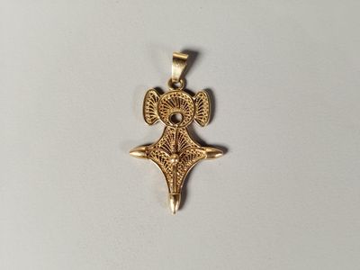 une image représentant un pendentif en or orné d'un oiseau