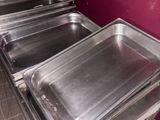 several trays of food are lined up on a counter in a kitchen