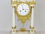 a white and gold clock sitting on top of a table