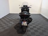 a black motorcycle parked in a room with a checkered floor