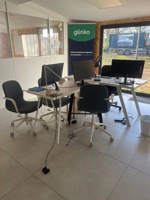 des tables et des chaises dans une pièce dotée d'une grande fenêtre et d'une affiche accrochée au mur