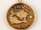 un gros plan d'une médaille d'or sur laquelle figure un poisson