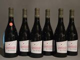 six bouteilles de vin rouge sont alignées sur une table