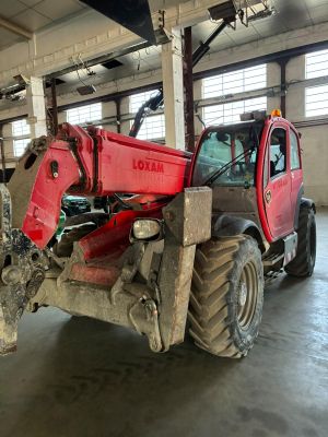 un tracteur rouge garé à l'intérieur d'un bâtiment