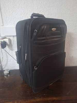 une valise noire posée sur une table en bois