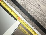 a measuring tape on the floor next to a window