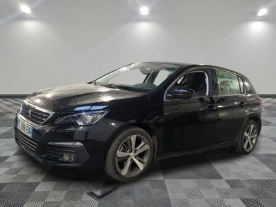 une voiture noire est garée dans une pièce au sol en damier
