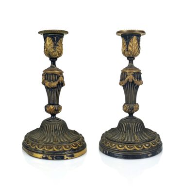 pair of black and gold candlesticks sitting on a white surface