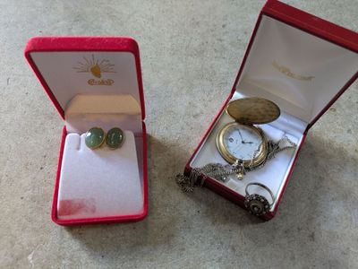a small box with a watch and a ring inside of it