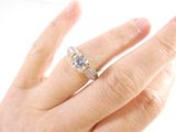 a woman ' s hand with a diamond ring on it