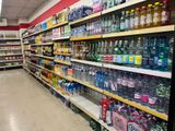 many bottles of water on the shelves in the store