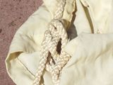 a white bag with a rope on it sitting on the ground