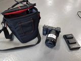 a camera, a cell phone, and a camera bag on a table