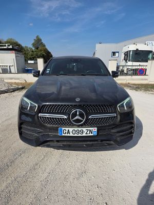La Mercedes GLE est garée sur un parking devant un immeuble.