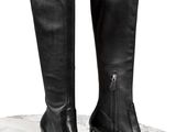 un gros plan sur une paire de bottes noires posées sur une surface en marbre