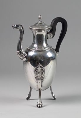 une théière ancienne en argent, dotée d'une poignée noire et d'une poignée noire