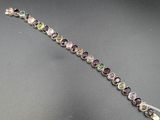 un gros plan sur un bracelet orné de nombreuses pierres de différentes couleurs