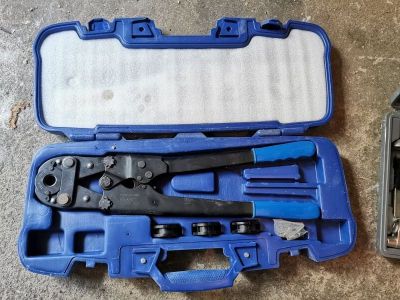une caisse à outils bleue avec des outils sur le sol