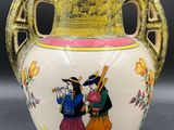a yellow vase with a picture of two people on it