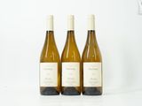 trois bouteilles de vin posées sur une table blanche