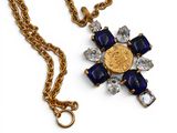 une image représentant un collier orné d'une pièce d'or et de pierres bleues