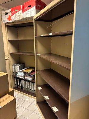 un placard rempli de cartons, avec des cartons empilés sur les étagères