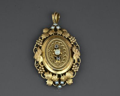 a close up of a gold pendant with a clock on it