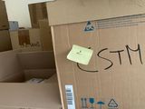 une boîte en carton sur laquelle est collé un autocollant, posée dans une pièce