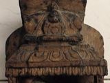 a wooden sculpture of a man and a woman sitting on a chair