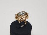 an image of a gold ring with a green stone on top