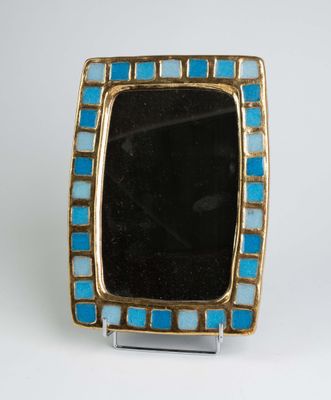 une image représentant un cadre bleu et or contenant une pierre noire