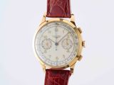 a close up of a wrist watch with a red strap