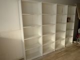 a white bookcase in a room with a hard wood floor