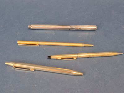 Plusieurs stylos sont alignés les uns à côté des autres sur une table.