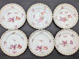 six plates with floral designs on them sitting on a table